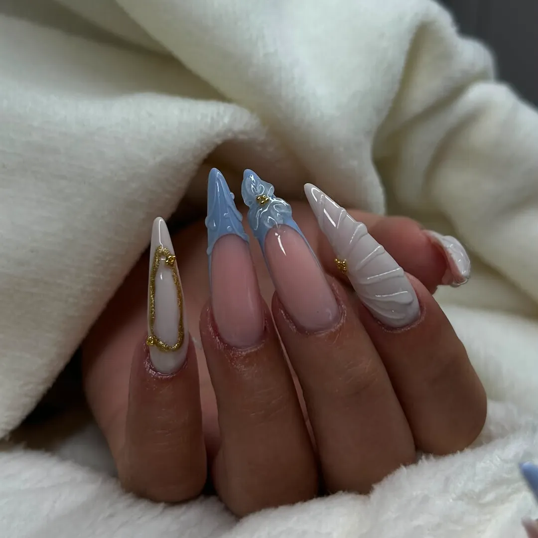 Nail art z modrimi in belimi 3D detajli ter zlato linijo